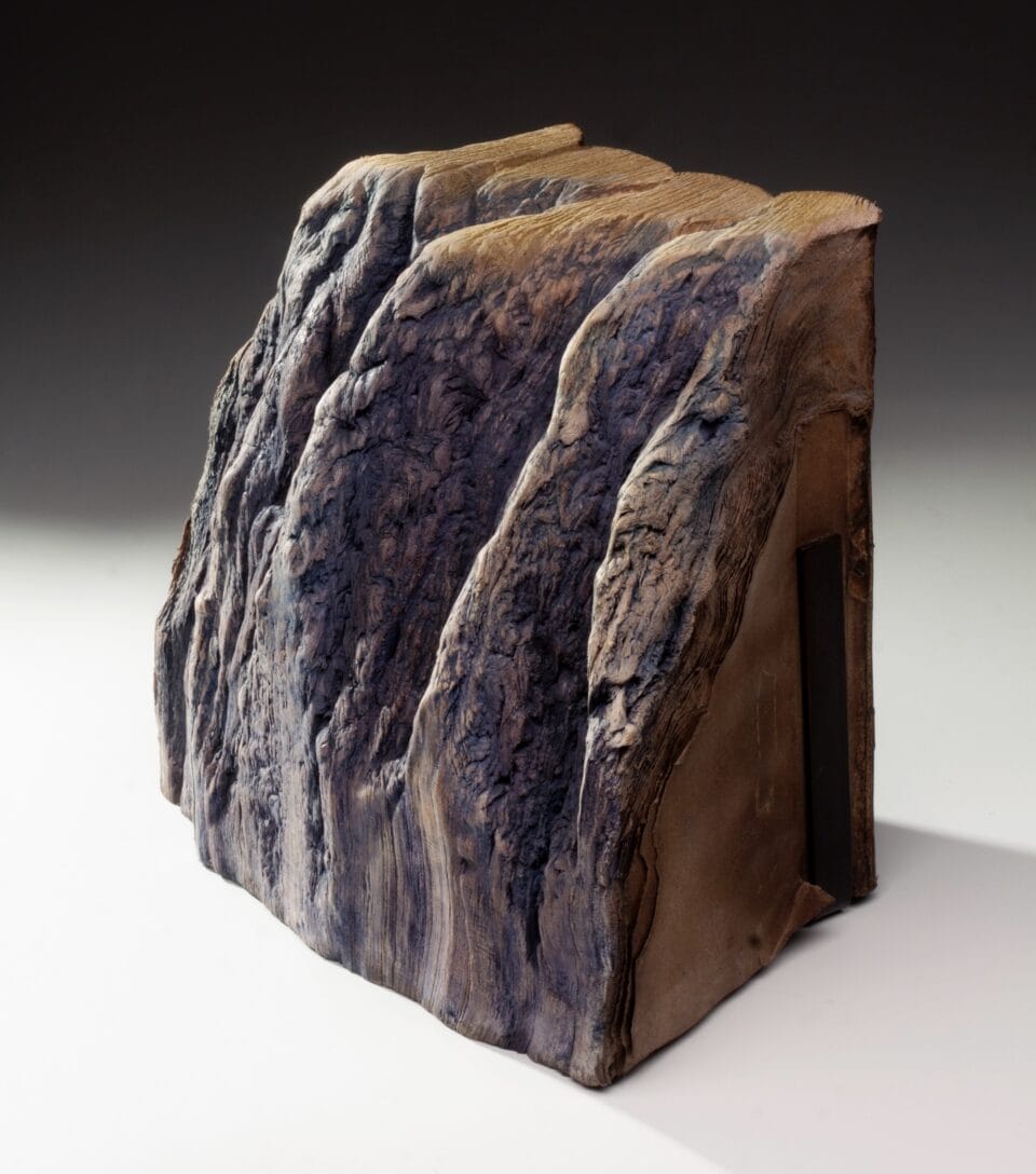 a sculpture made from a set of large books, covers removed to reveal the stitched binding, which has been water-blasted to soften and manipulate the pages into a form resembling a large mountain