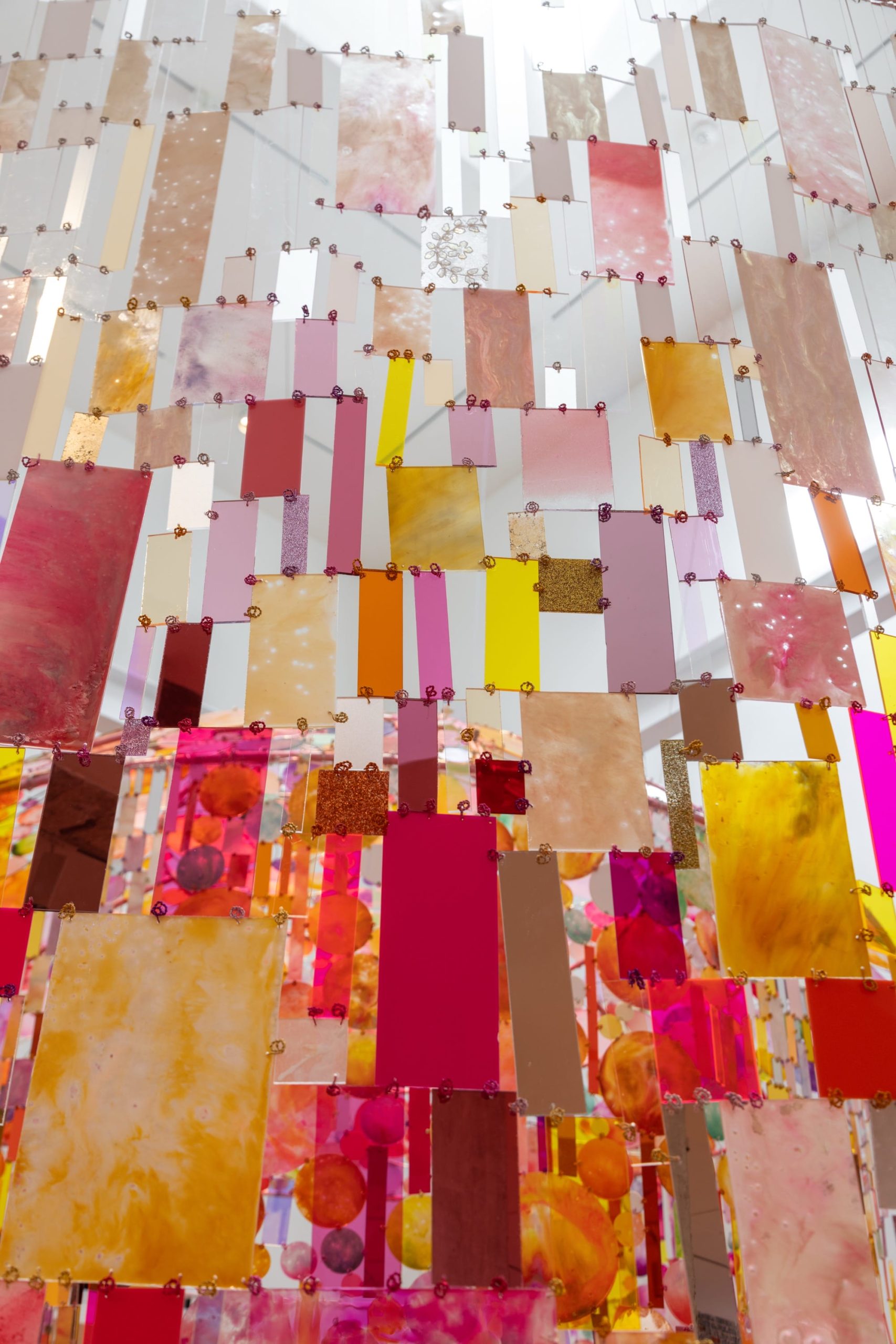 a detail of rectangular pieces of colorful material, part of a suspended tapestry installation