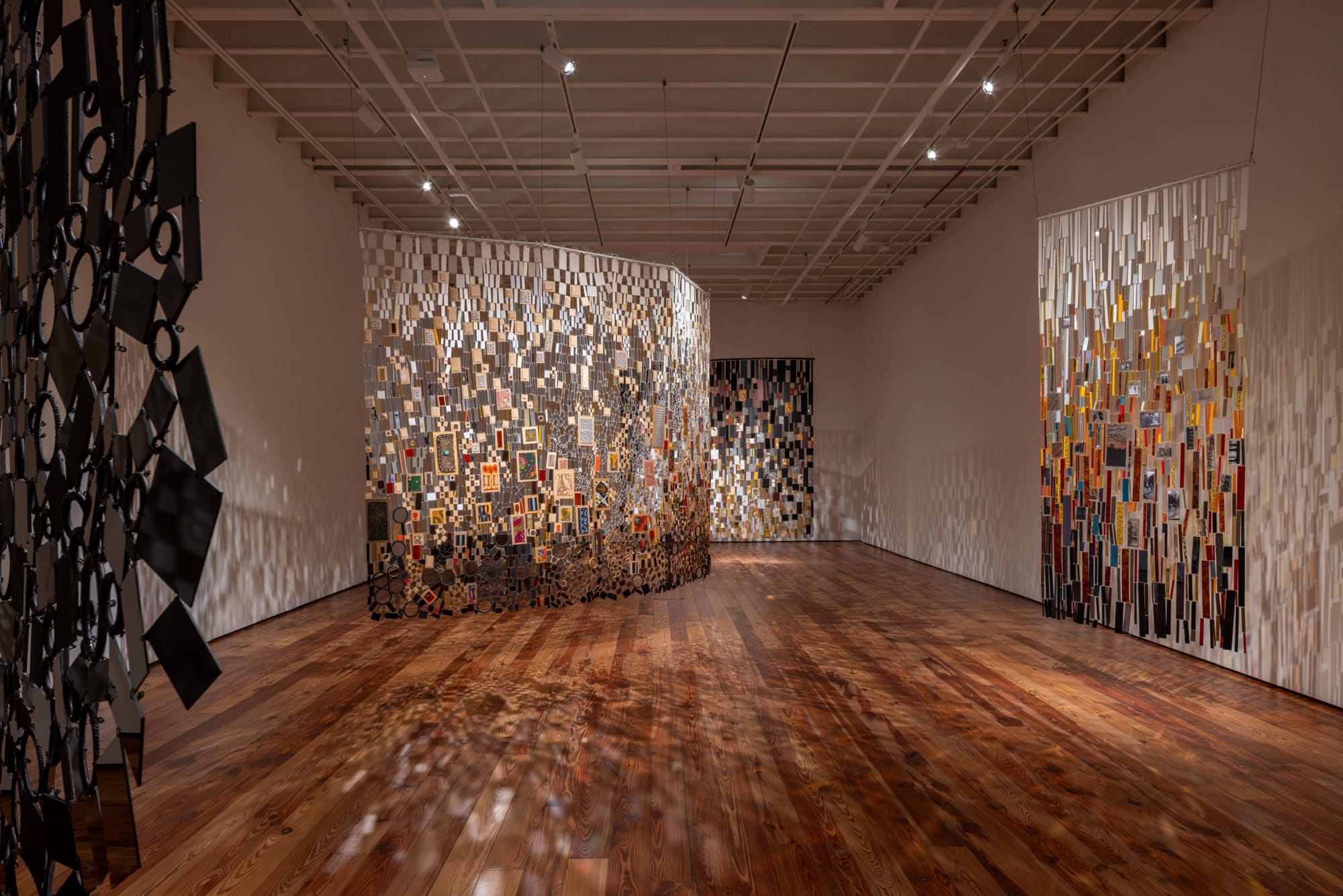 an installation view of suspended mixed-media tapestry installations