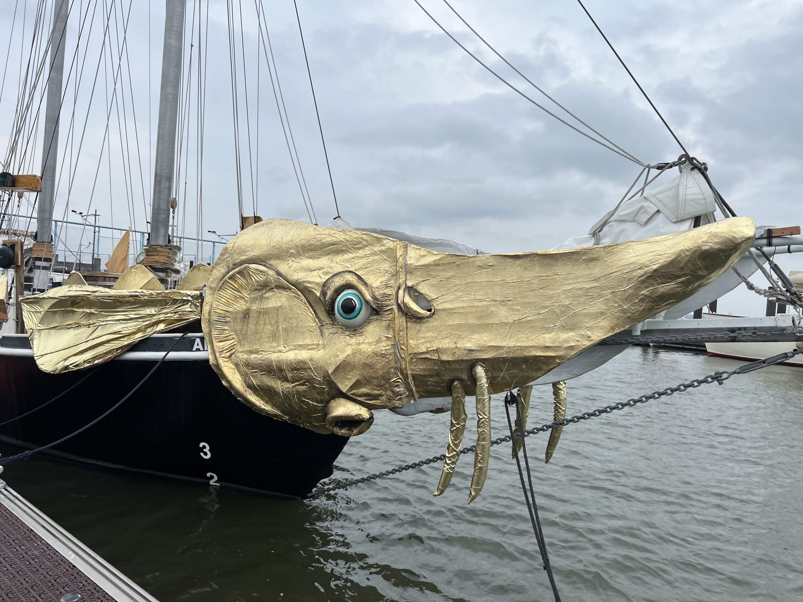 a detail of a sailing ship on the Hudson River with gold decorations to make it look like a fish