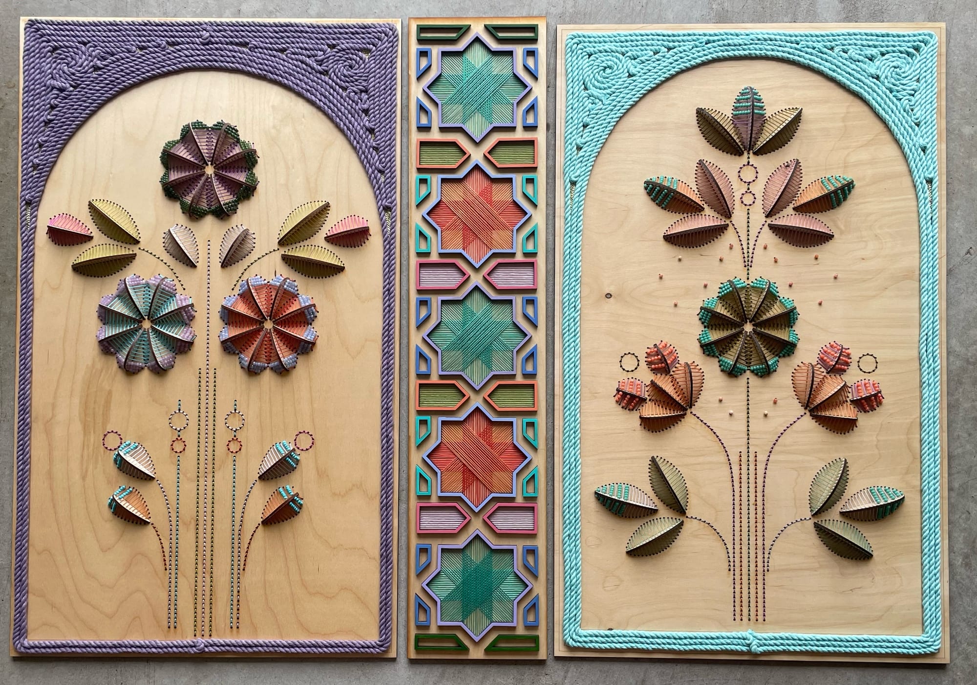 three sculptural floral embroideries on wood