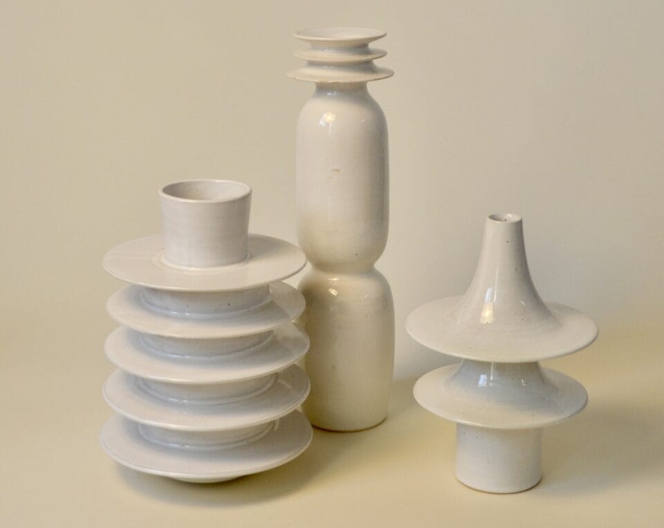 three geometric vessels in bright red and deep yellow