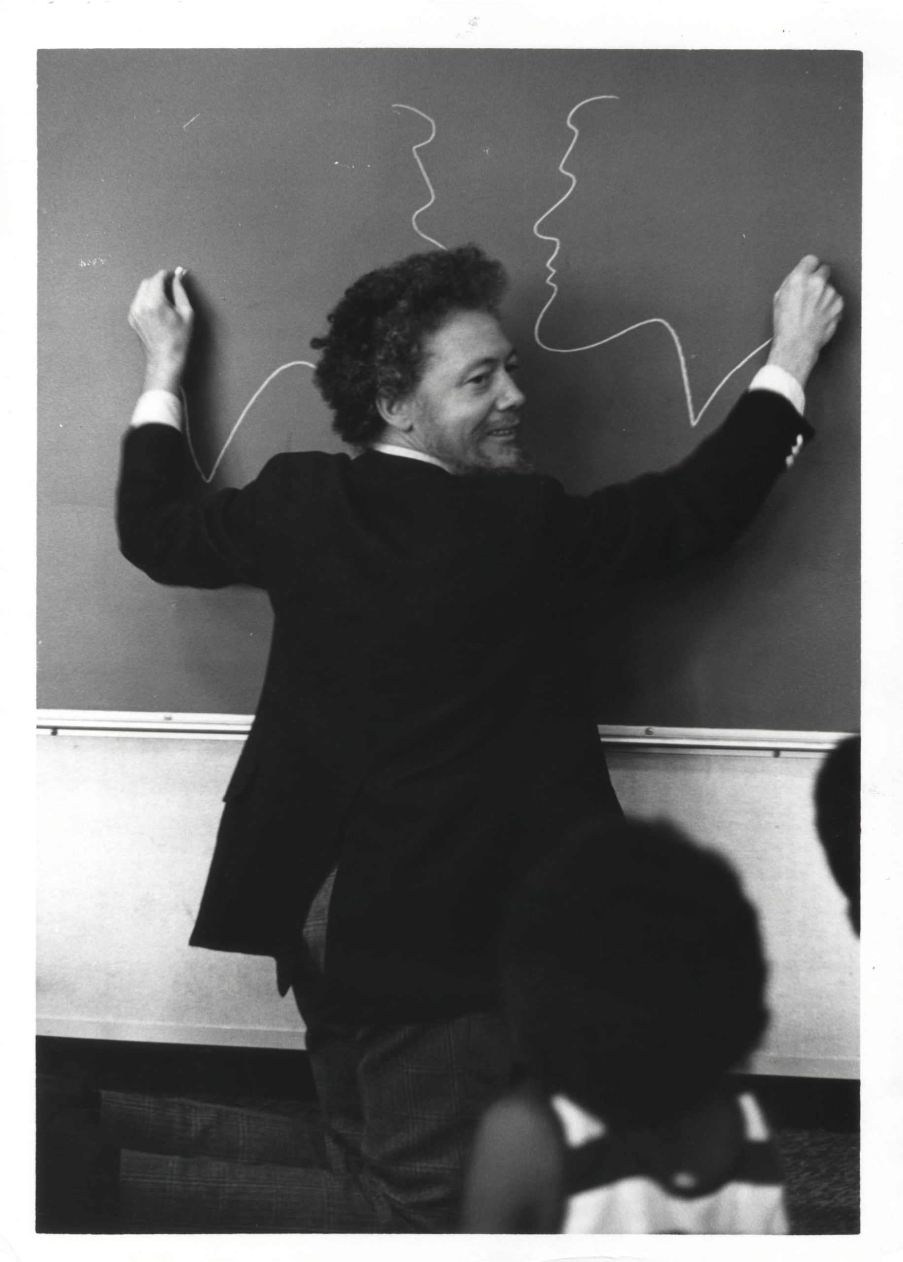 a man draws on a chalkboard with both hands