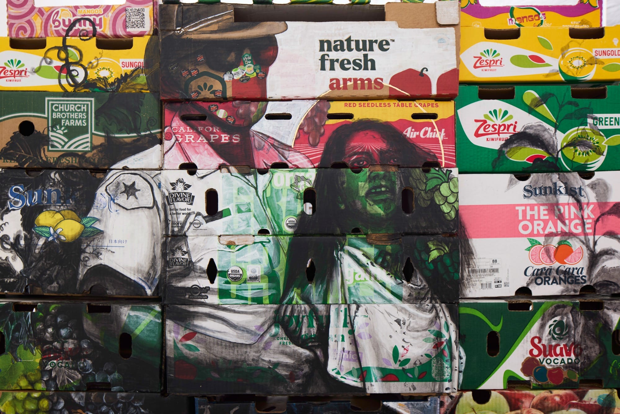 a detail of an artwork by Narsiso Martinez showing a young girl being detained by a masked man in uniform, drawn on farm produce boxes