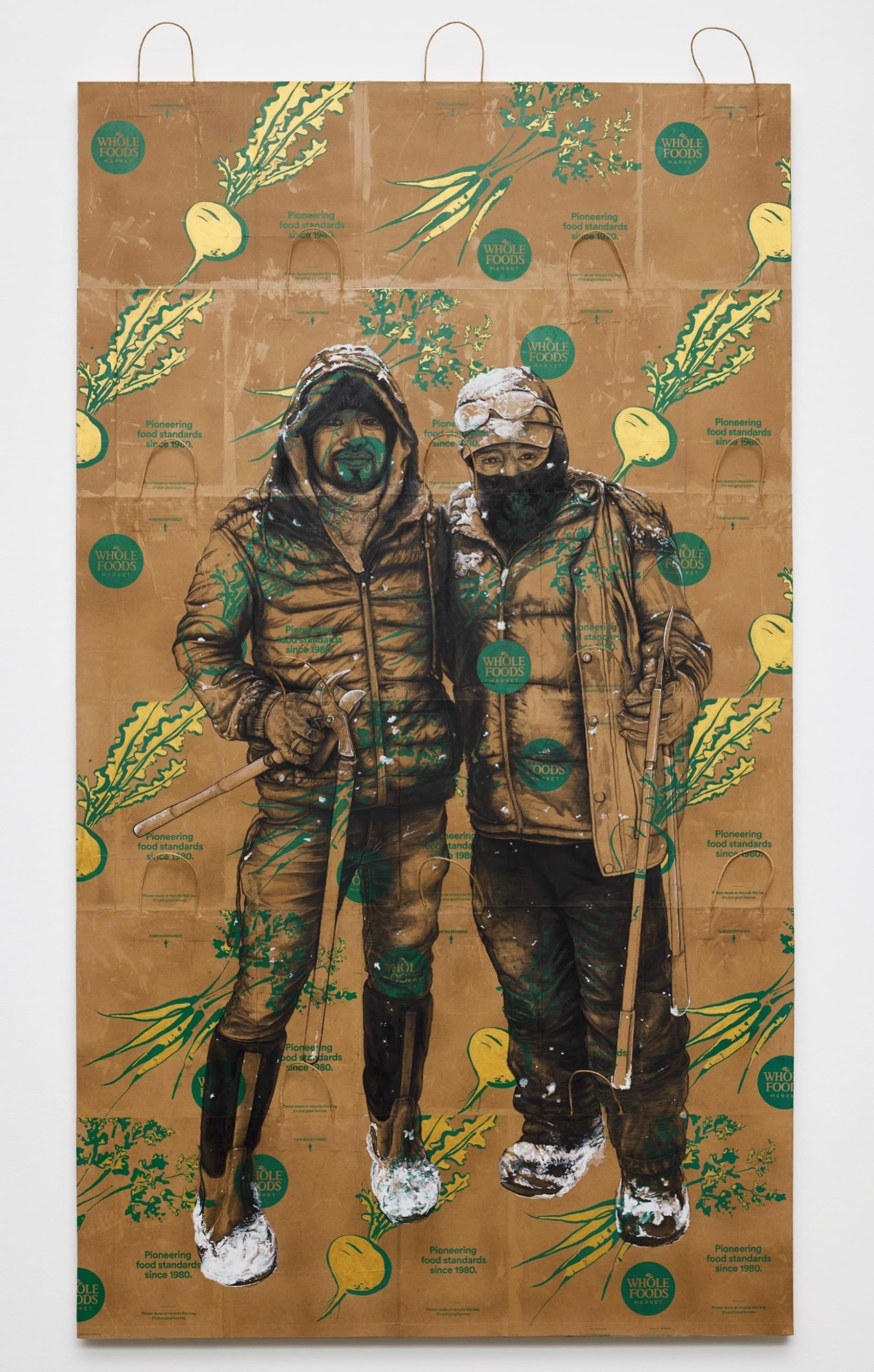 a vertical portrait of two men on an assemblage of kraft paper bags by Narsiso Martinez