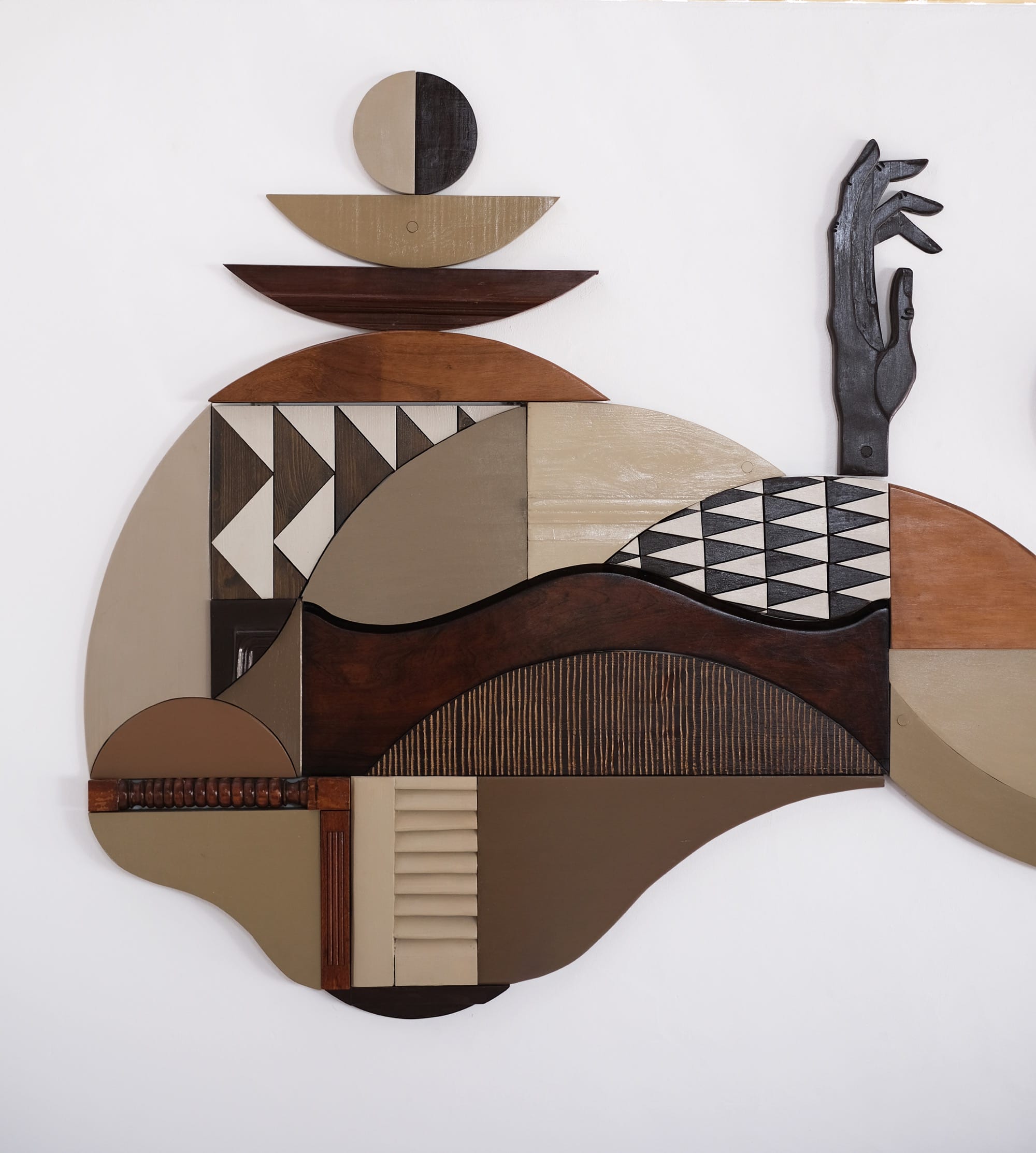a detail of a wall installation made of wood in various patterns, colors, and textures