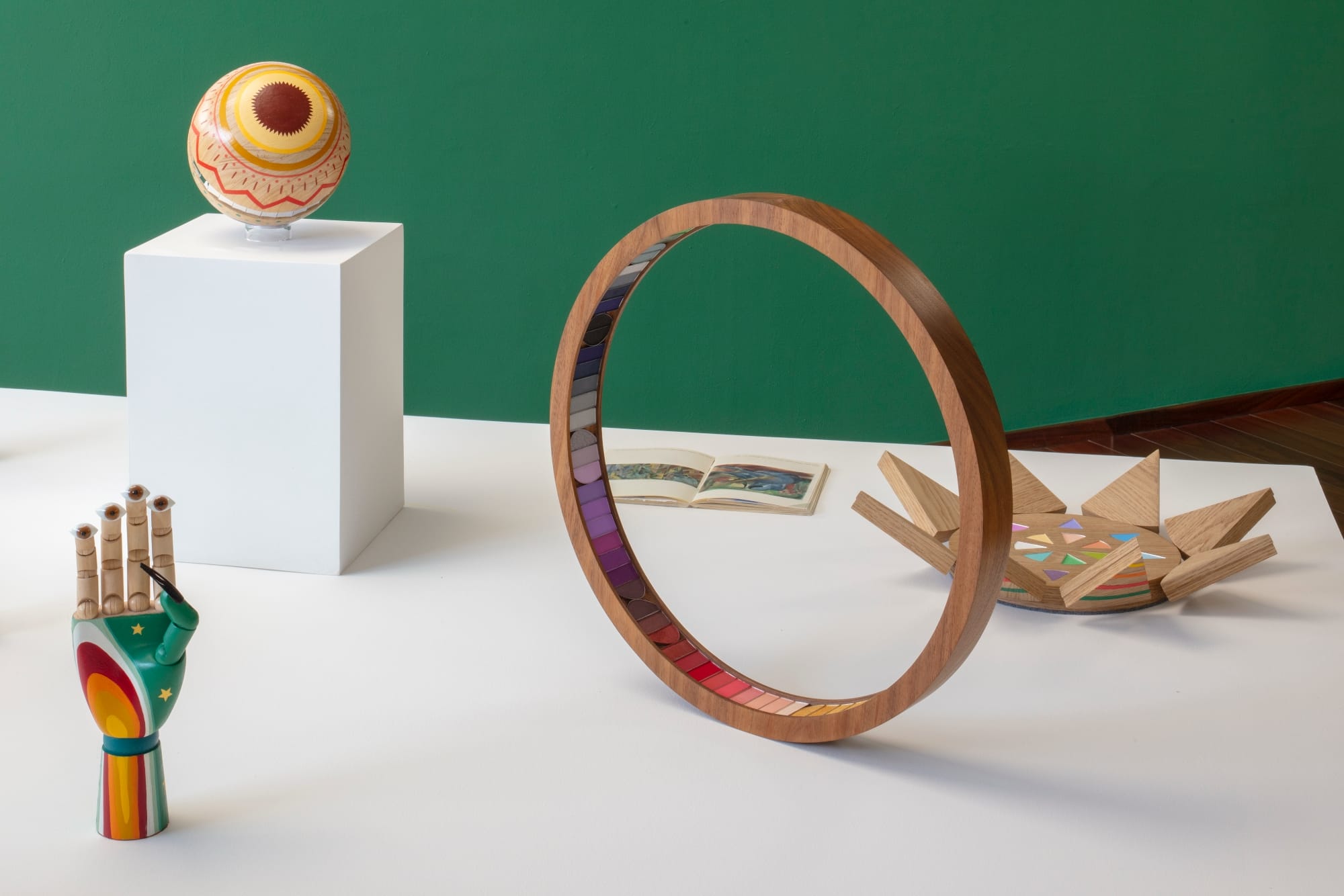 a collection of wooden sculptures on white pedestals