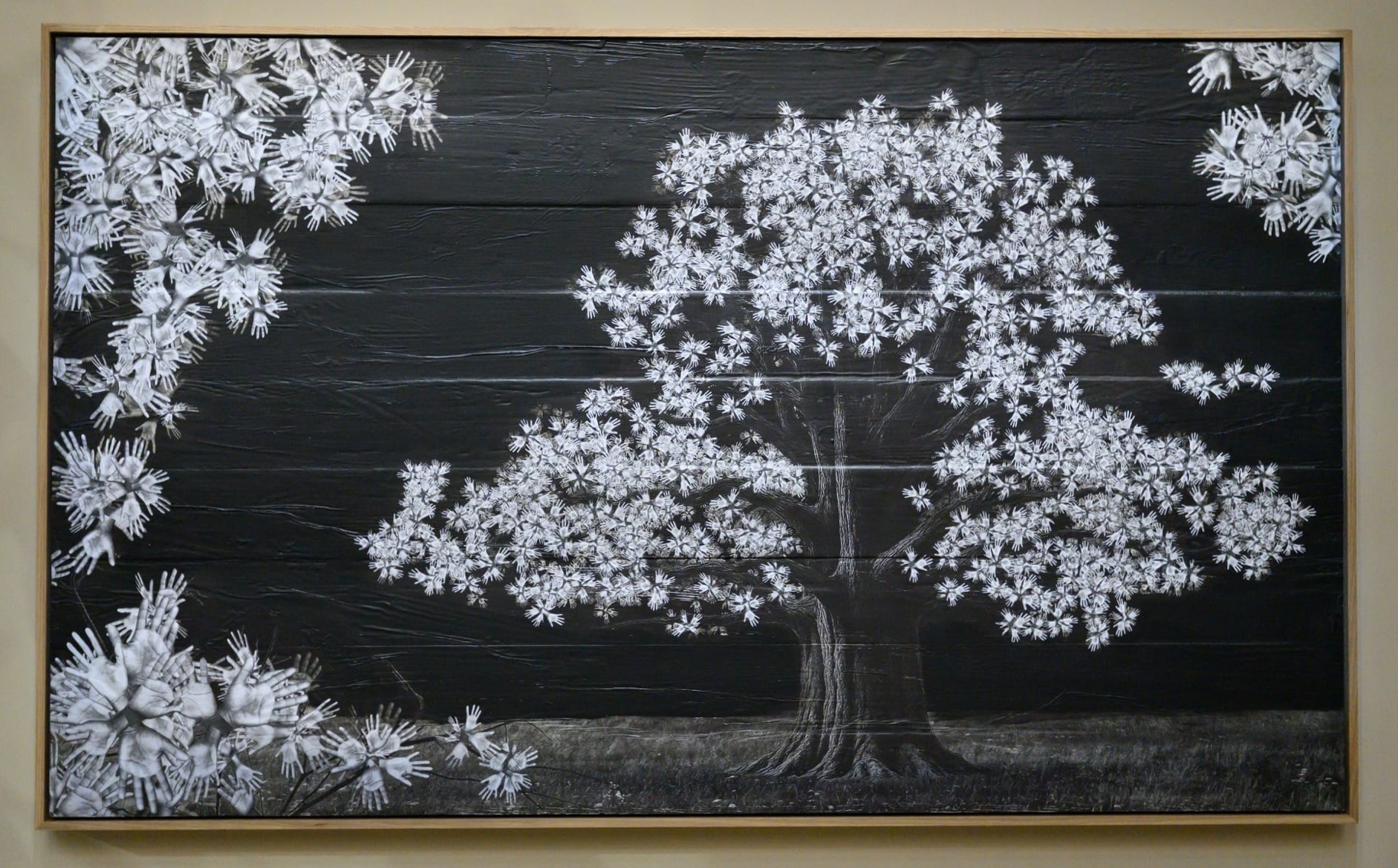 a wall work of a tree with leaves made of hands