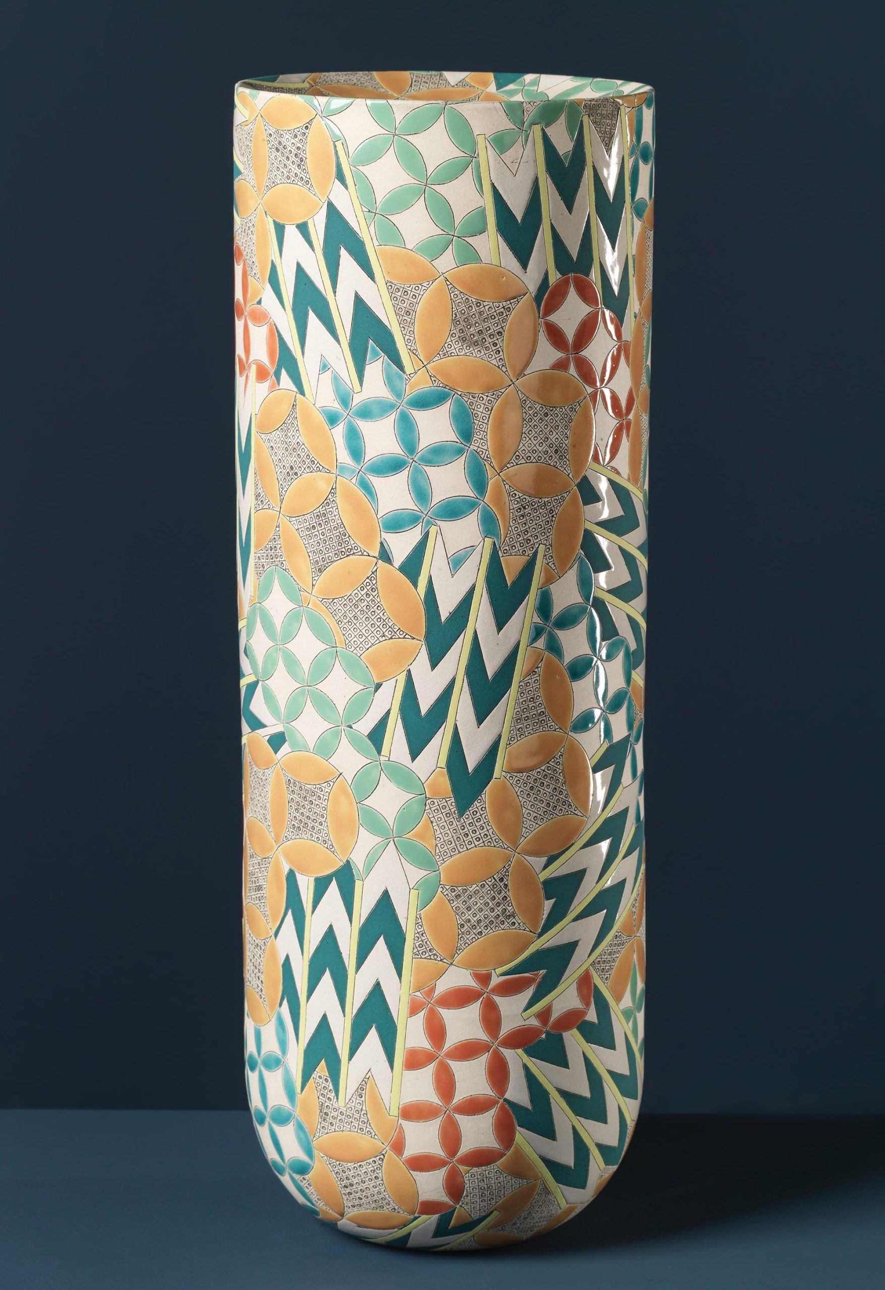a colorful, geometrically patterned, cylindrical ceramic form