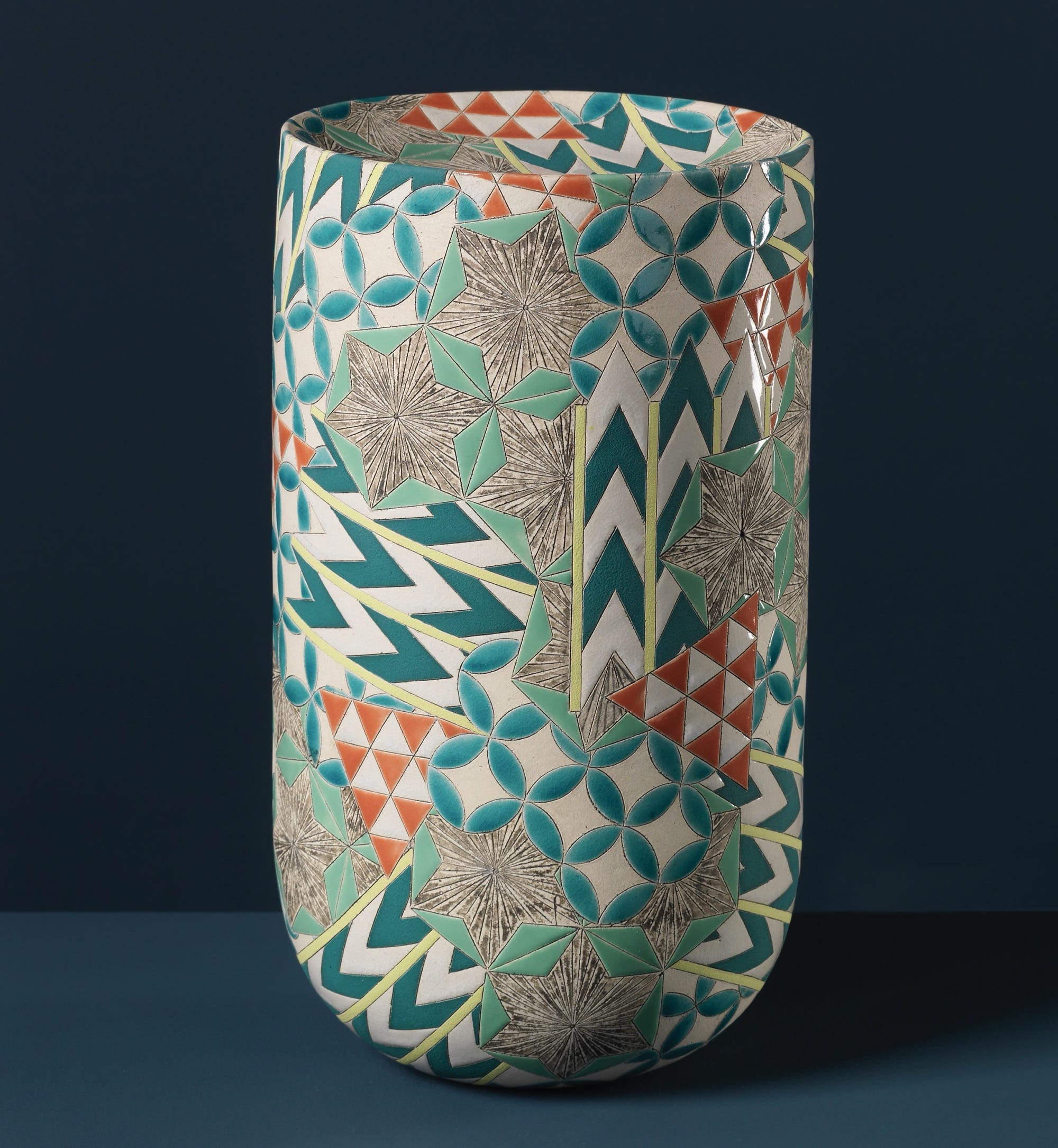 a colorful, geometrically patterned, cylindrical ceramic form