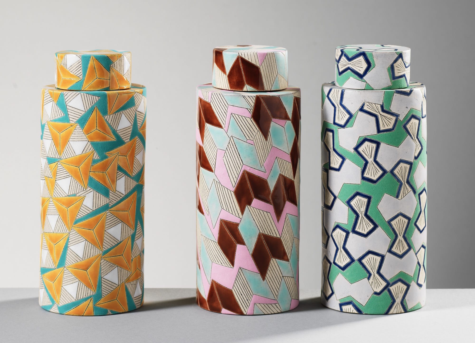 three geometrically patterned, cylindrical jars