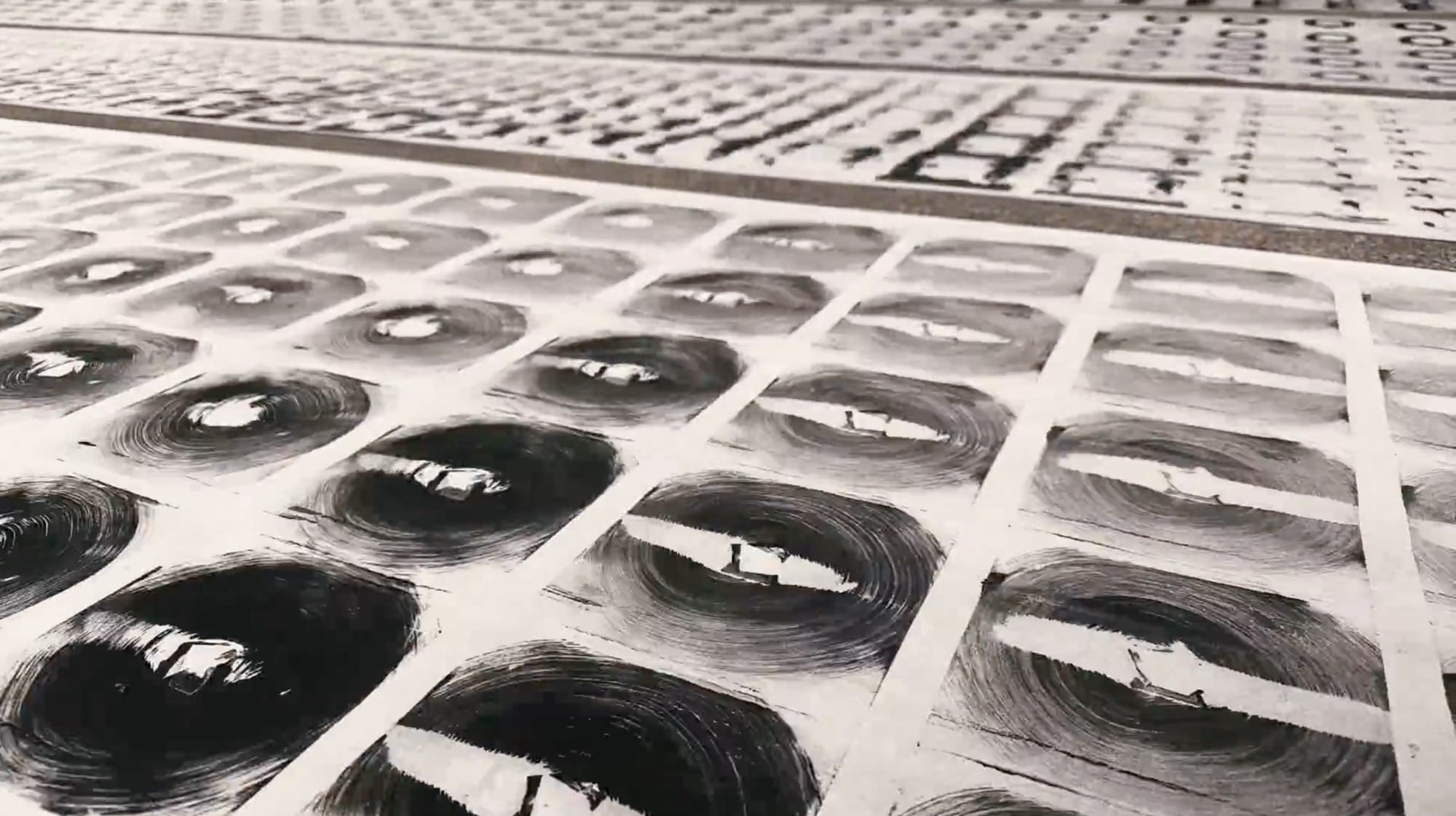 details of scrolls of patterned paper laying in rows on a concrete floor