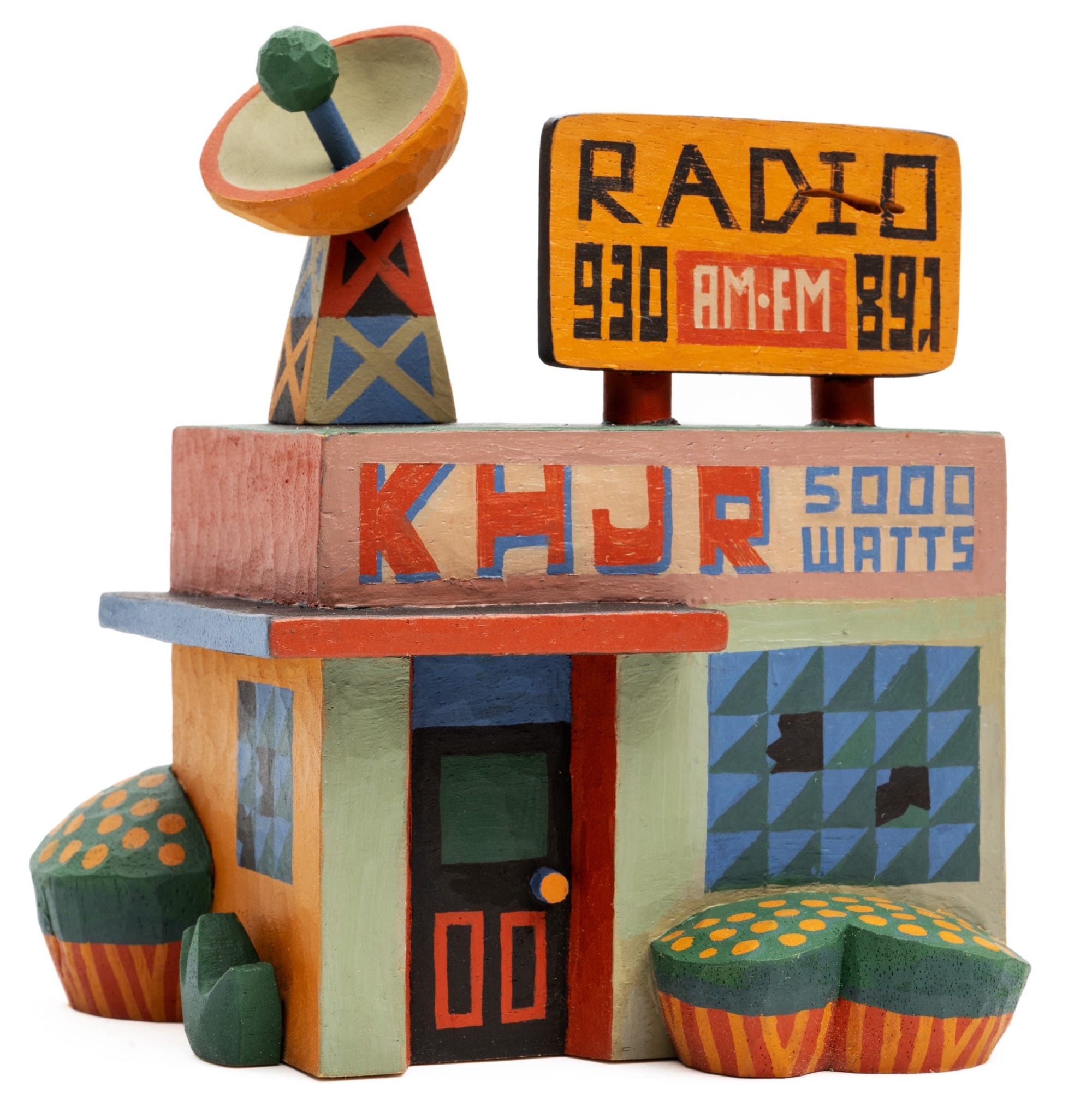 a colorful, hand-carved wooden sculpture of a radio station, KHJR