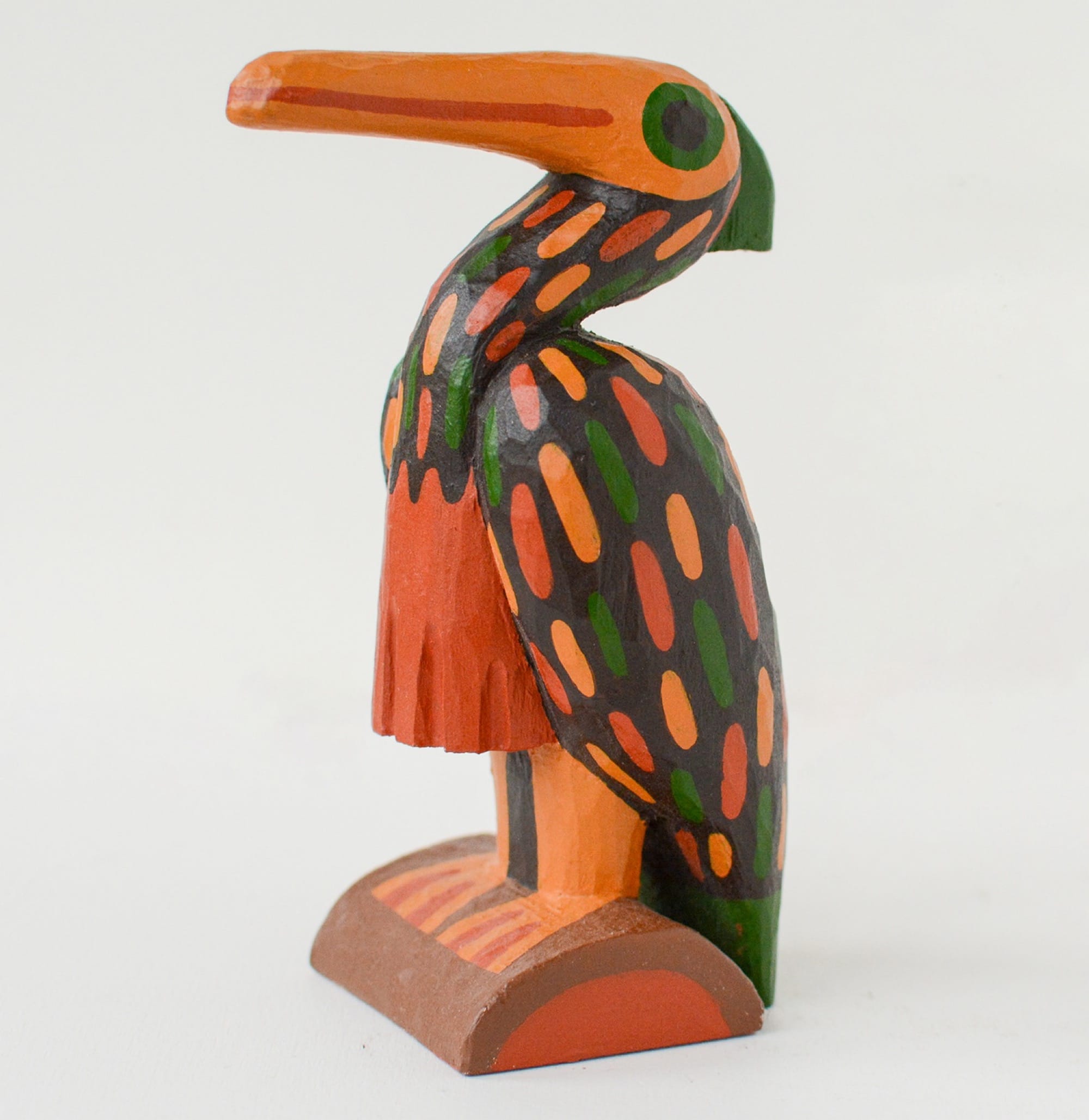 a colorful, hand-carved wooden sculpture of a pelican