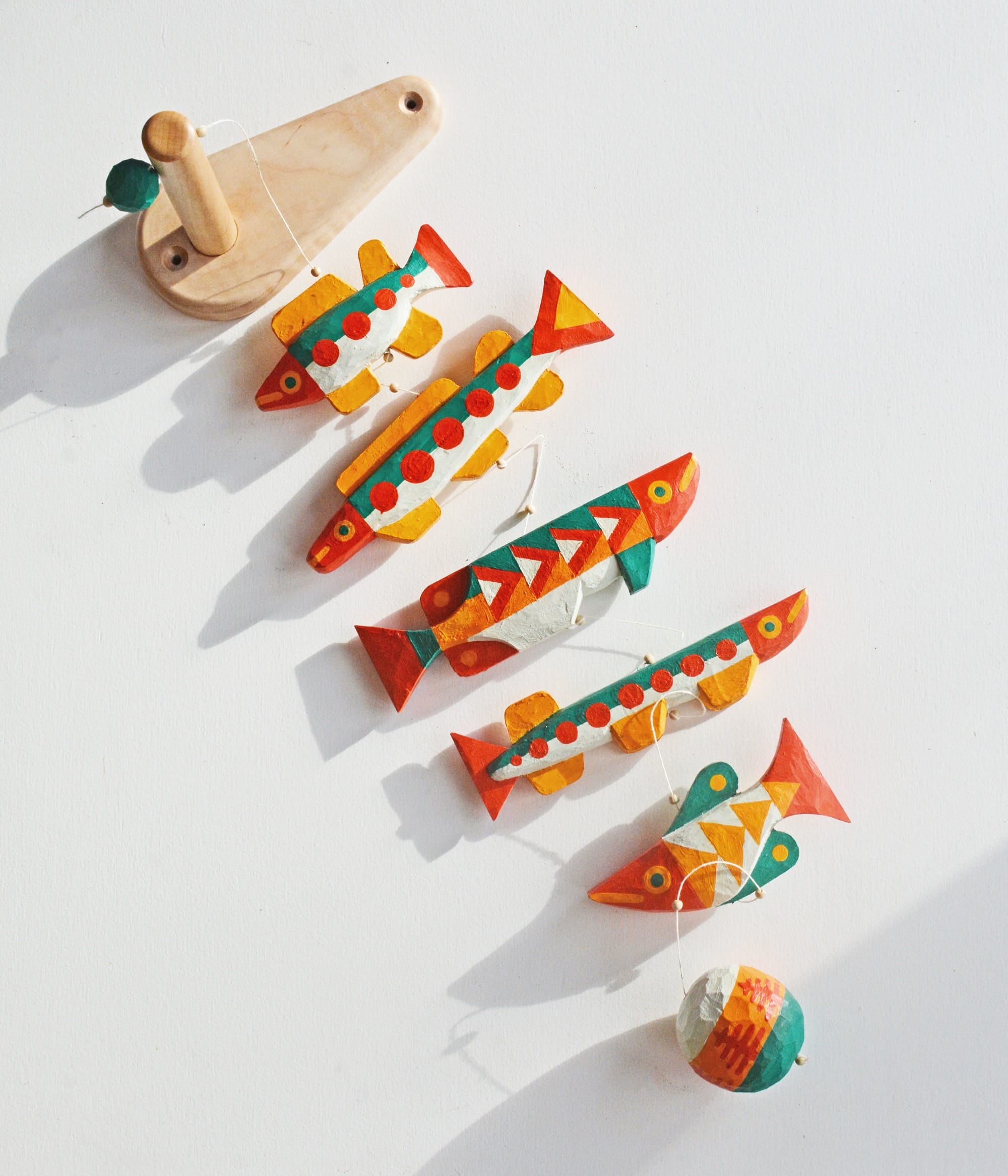 colorful, hand-carved wooden sculptures of fish in a row
