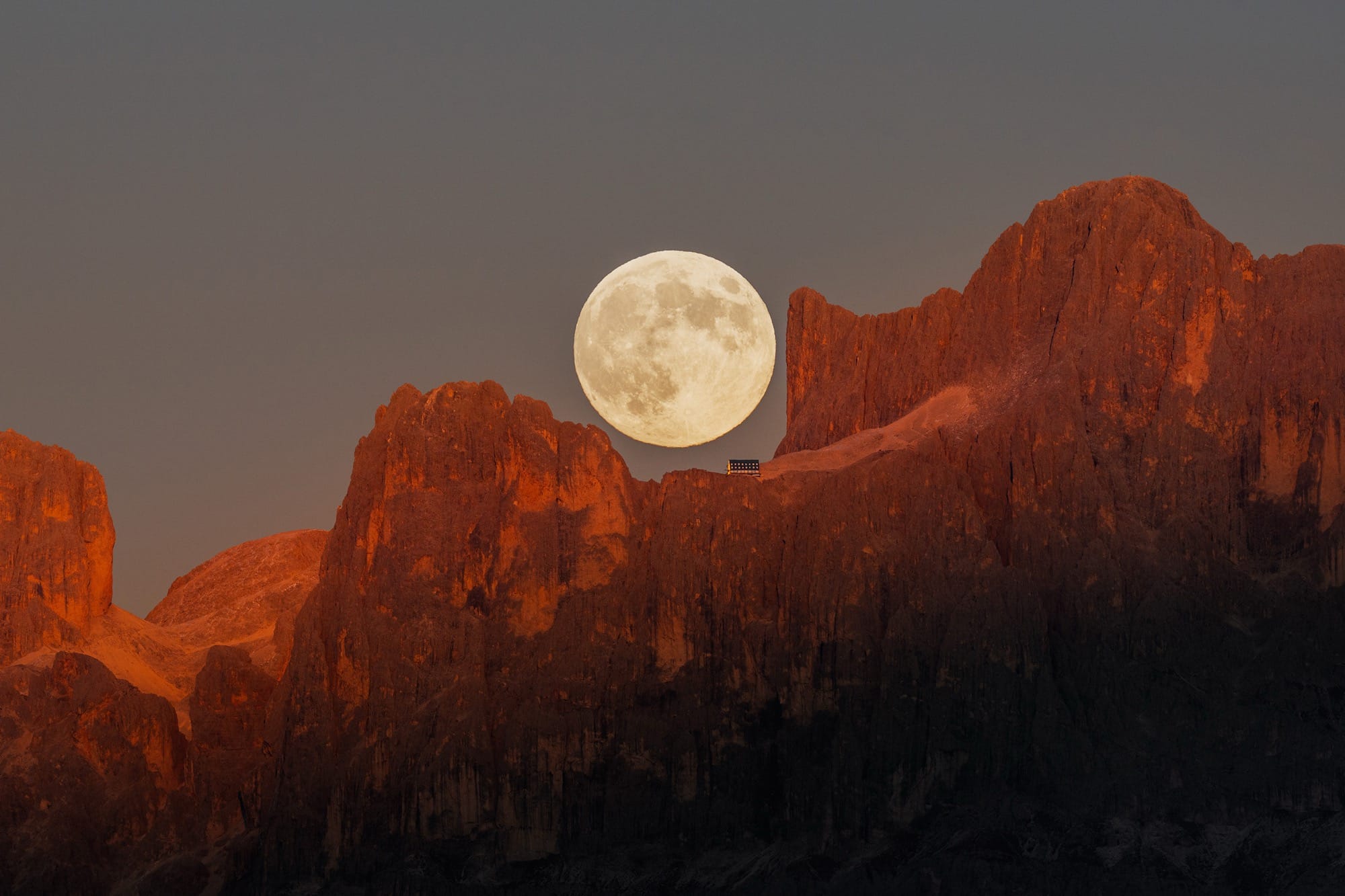 a full moon rising over the Dolomites